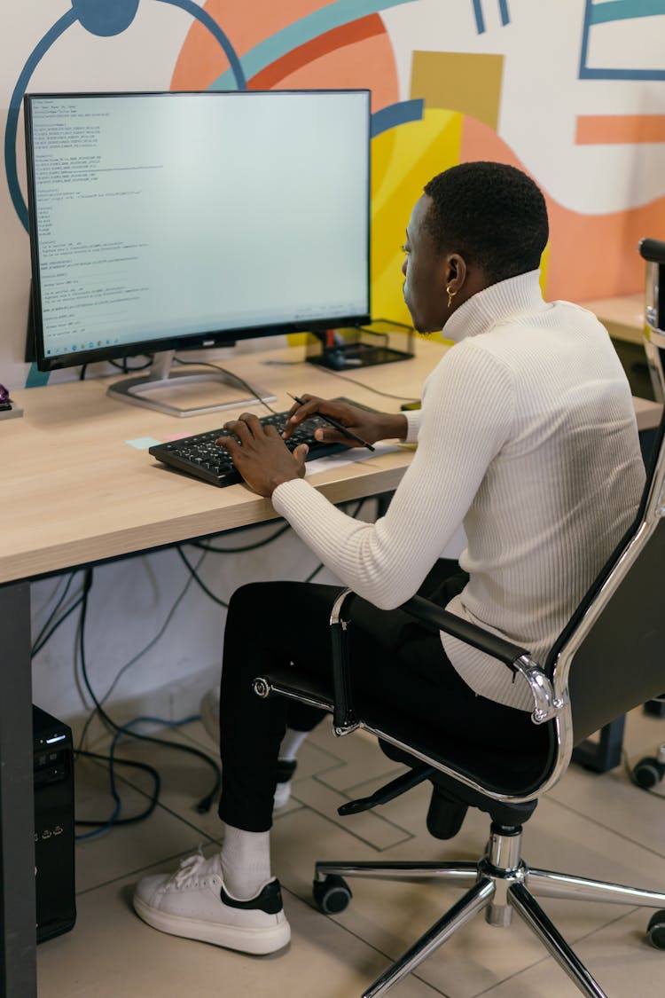 Man In White Sweater Working With A Computer