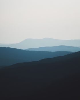 A peaceful landscape of silhouetted mountains under a twilight sky, capturing serene beauty.