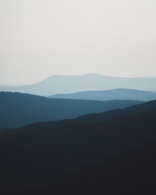 Free A peaceful landscape of silhouetted mountains under a twilight sky, capturing serene beauty. Stock Photo