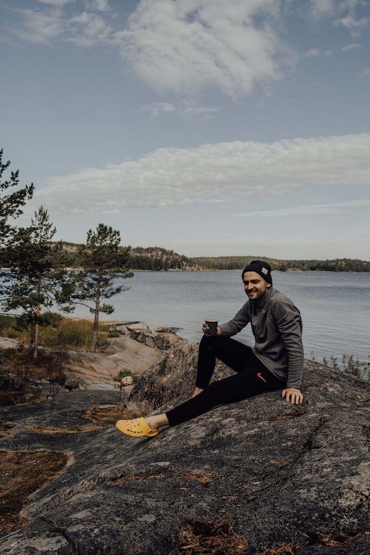 Man Sitting On The Ground While Holding A Cup