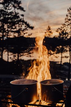 Captivating campfire scene with pots in Ruskeala, Karelia during twilight.