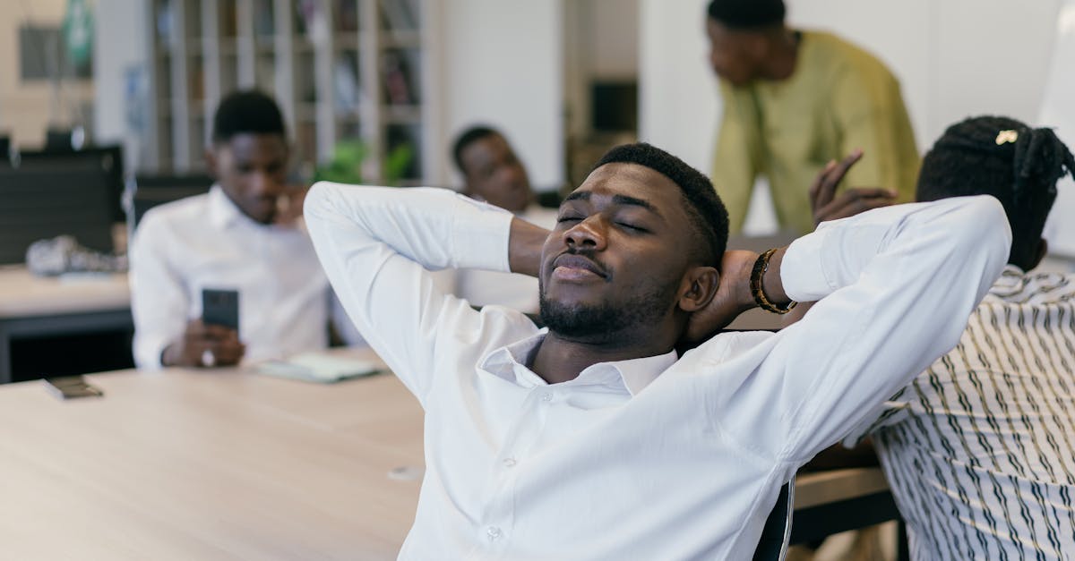Office workers take a break, relaxing at desks in an open plan space.
