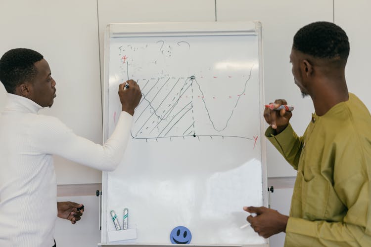 Men Drawing A Chart On The Whiteboard