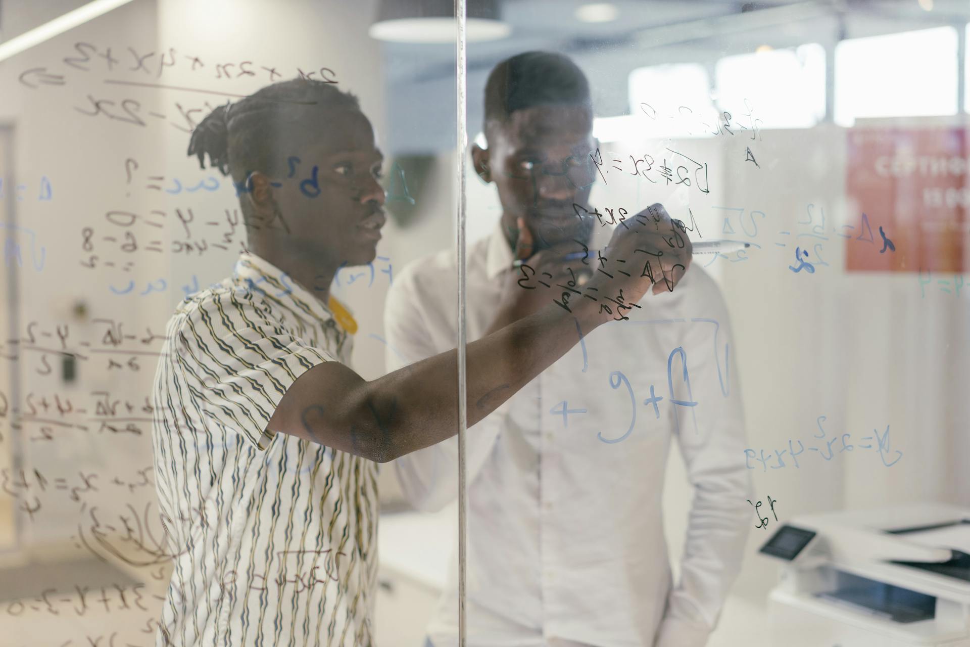 Employees Discussing the Topic on the Glass Board