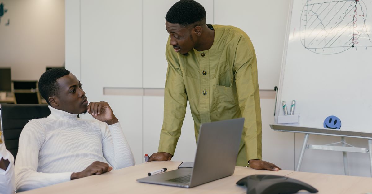Two men in a business meeting discussing strategies in a modern office setting.