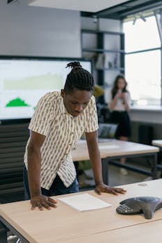 Focused business professional analyzing documents in a modern office setting during the day.