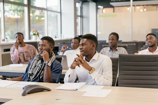 A group of men attentively participating in an office meeting, displaying teamwork and collaboration.