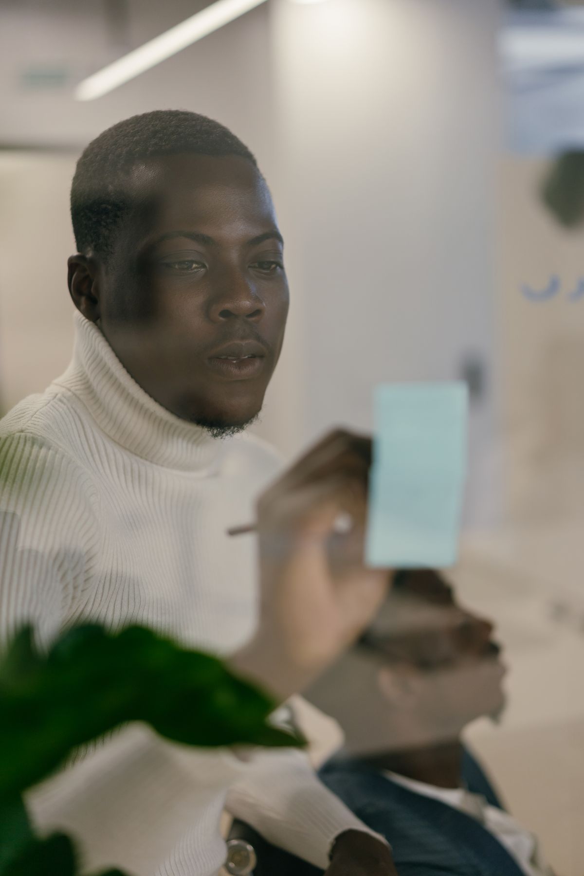 African professional writing strategy on a glass board in a modern Nairobi office