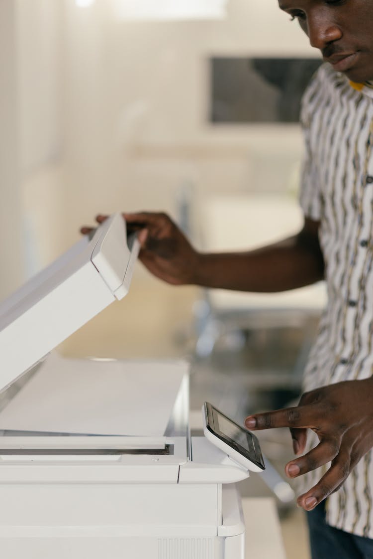 A Man Operating A Photocopier