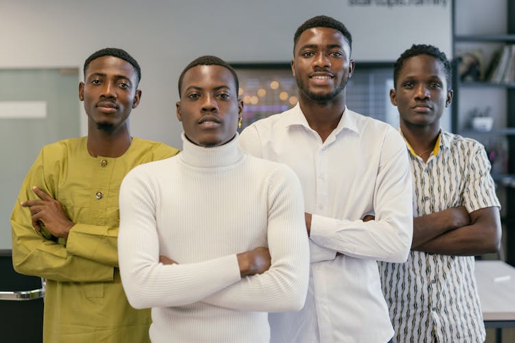 A Group Of Men Standing With Their Arms Crossed