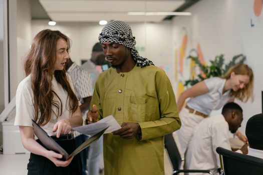 Diverse group of coworkers collaborating in a modern office setting, emphasizing teamwork.