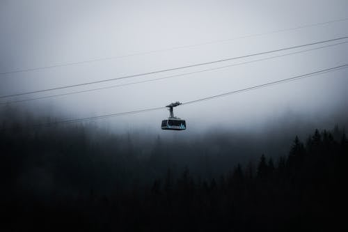 Cable Car Passing over a Foggy Forest