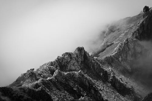 Grayscale Photo of a Cloudy Mountain