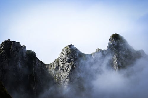 Thick Fog Partially Covering a Rock Mountain