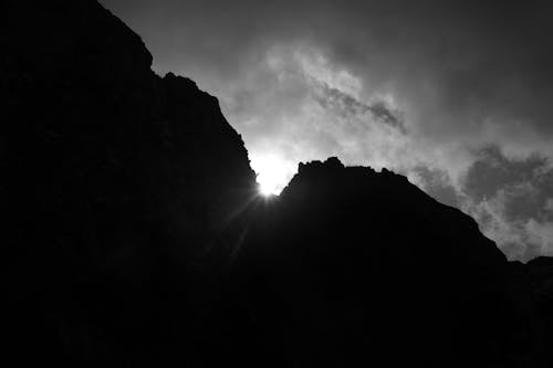 Grayscale Photo of Mountain Under the Clouds