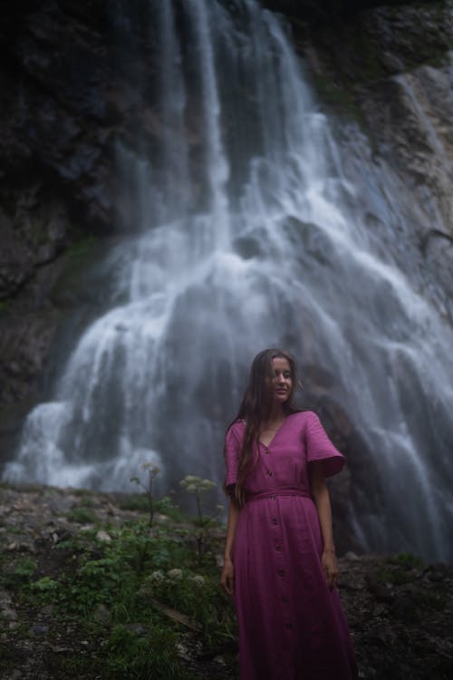 A Woman in Purple Dress with Waterfalls Background