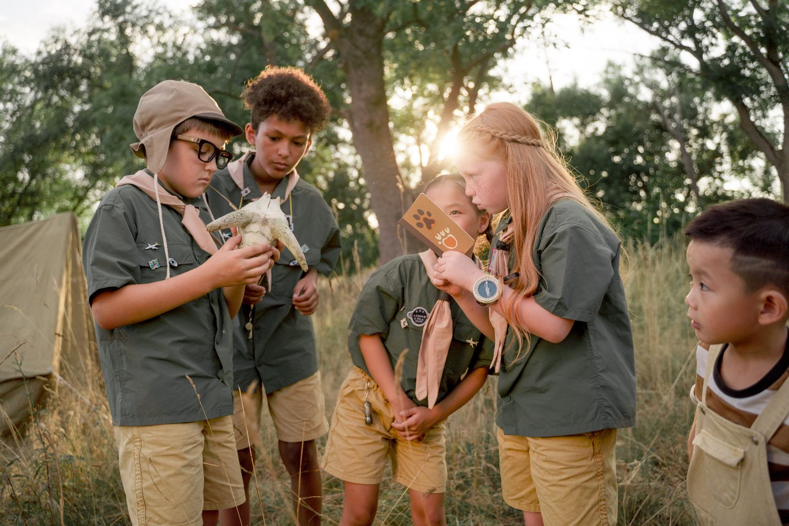 A group of children explore nature together outdoors during summer camp, the kind of bulk program buyer sourcing kids' backpacks.