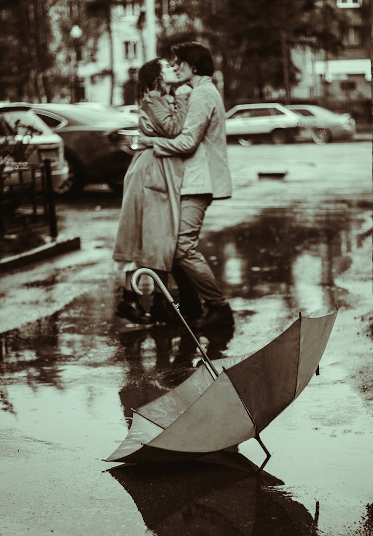 A Romantic Couple Kissing In The Rain