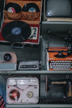 A diverse collection of vintage audio and office equipment, including a typewriter and a phonograph turntable.