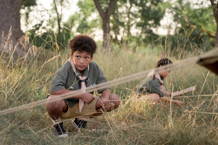 A Boy Setting Up A Tent