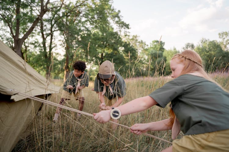 Photograph Of Kids Setting Up A Tent