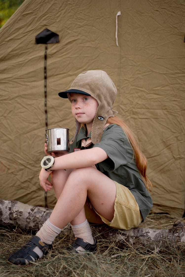 A Girl Scout Drinking From A Tin Cup