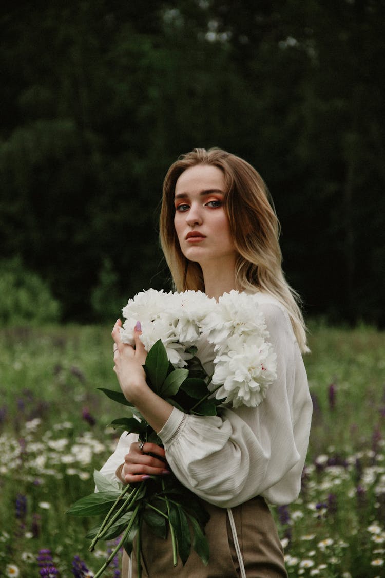 Woman In White Long Sleeve Dress Holding White Flower Bouquet