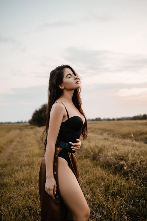Woman in Black Spaghetti Strap Top Standing on Brown Grass Field