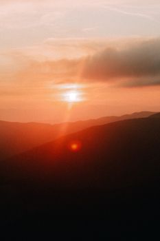 Capture the tranquility of a golden hour sunset over mountains.
