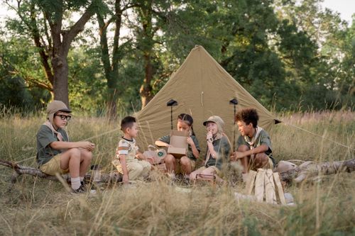 Free A group of children camping in the wilderness, enjoying outdoor activities and nature exploration. Stock Photo