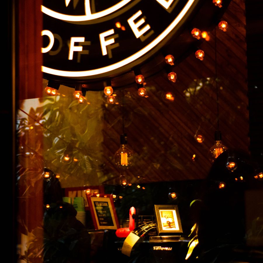 Warm window light and the coffee sign at dusk