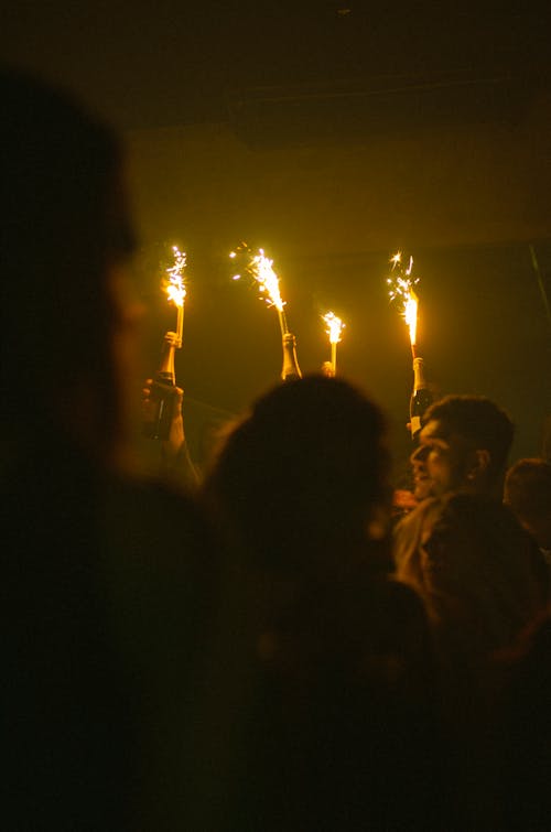 Dark Image of People Holding Yellow Fireworks