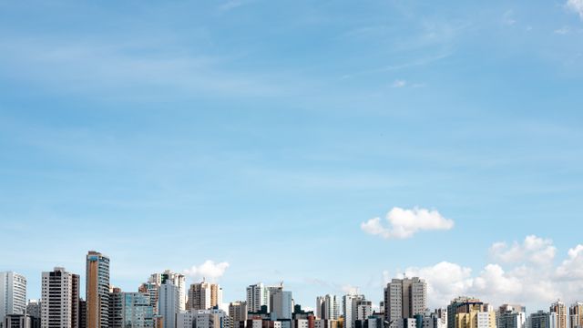 Distant view of Brasília skyline with bright blue sky and fluffy clouds.