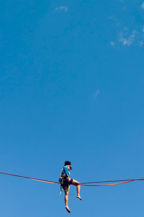 Free Daring slackliner balancing high in the skies of Cavalcante, Brazil, under a vivid blue sky. Stock Photo