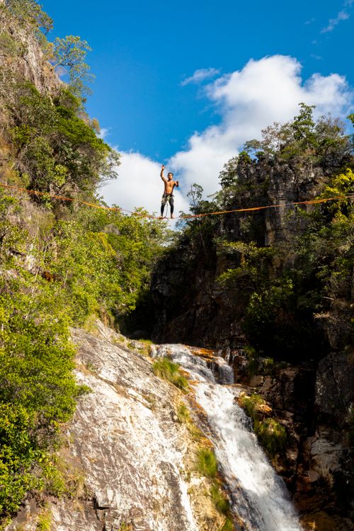 Free A man balances on a rope over a waterfall in Cavalcante, Brazil. Stock Photo