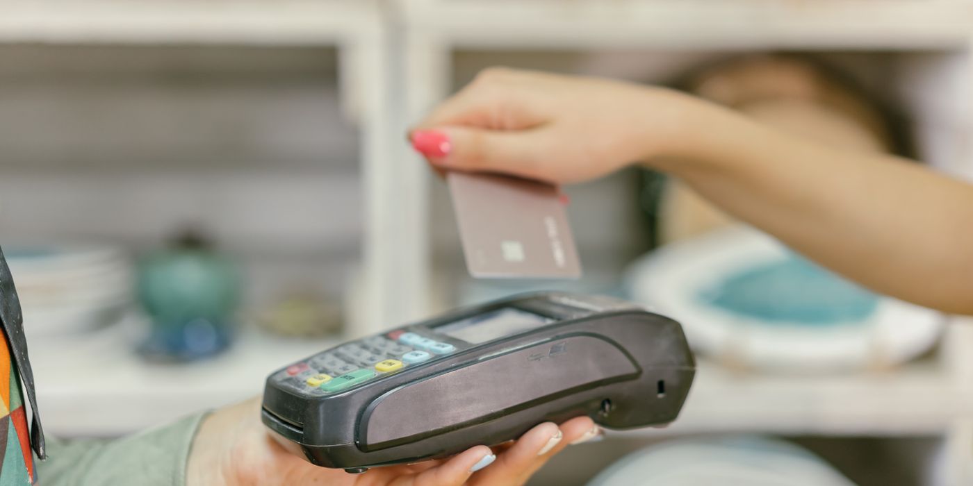 Person reviewing a payment card and a booking on a laptop
