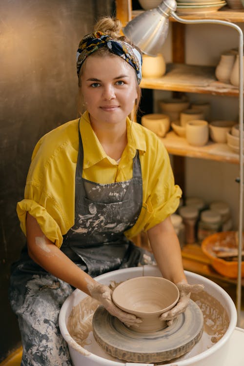 Pretty Woman Forming Dish on Potters Wheel with Hands