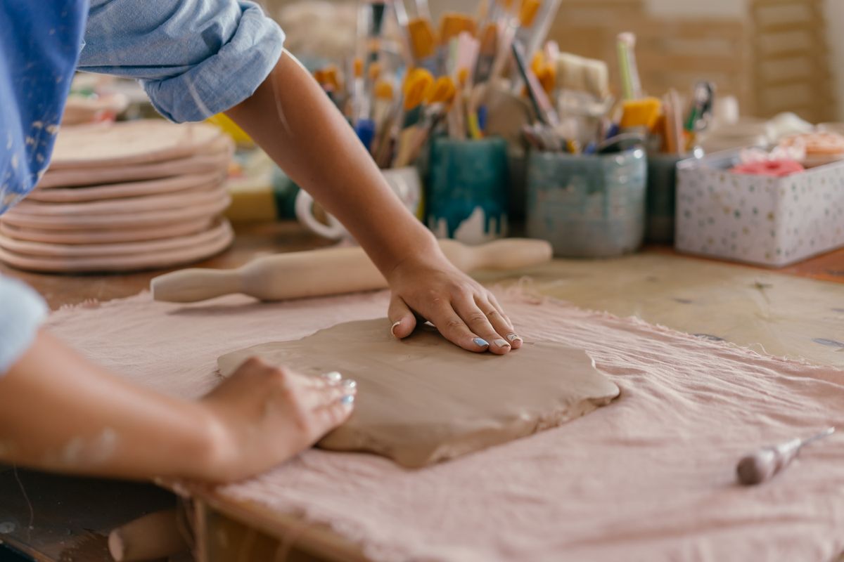 Close-up of hands shaping clay on a pottery wheel in a creative workshop