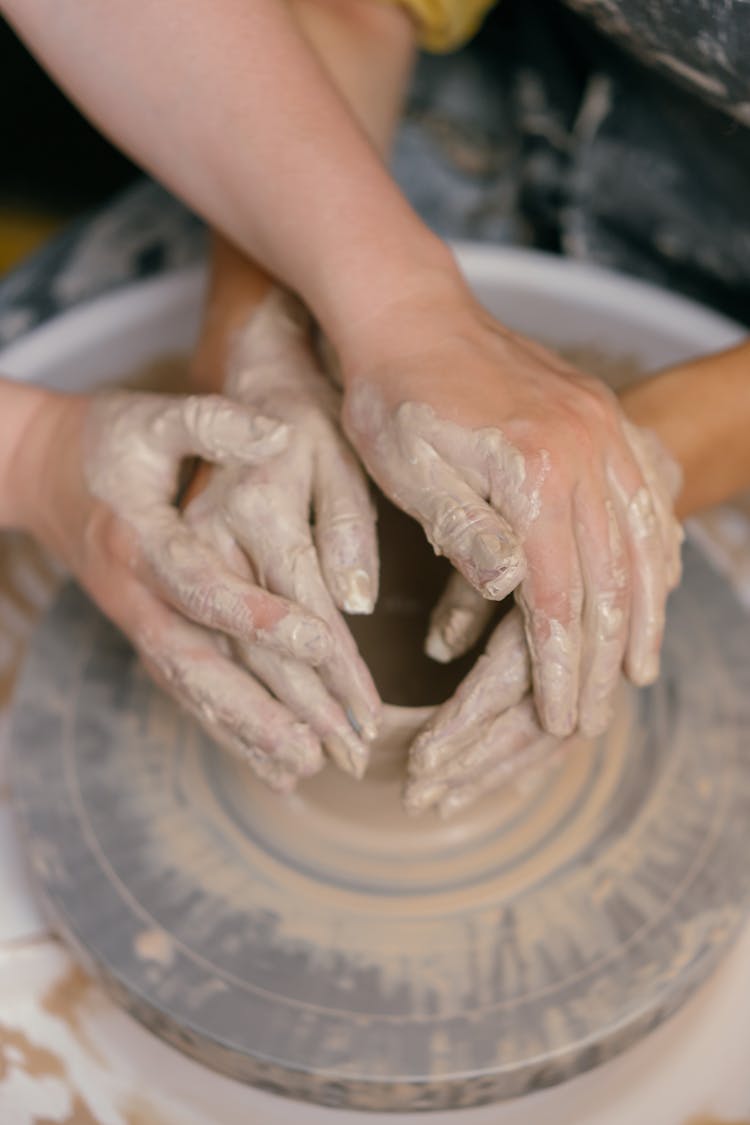 Two People Sculpting A Pot 