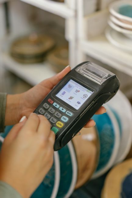 Hands operating a POS machine for payment processing in a retail setting. Hands operating a POS machine for payment processing in a retail setting.