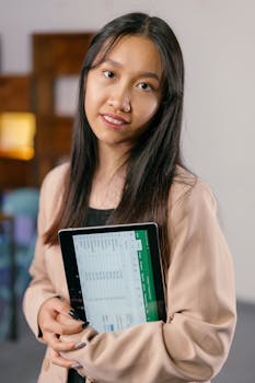 Confident woman in business attire smiling while holding a tablet with visible charts.