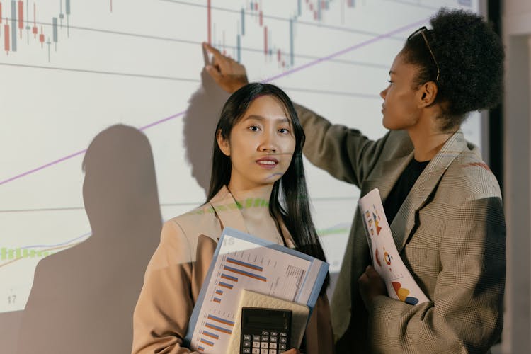 Female Colleagues Beside An Analytics Board 