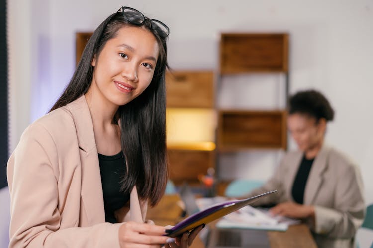 Woman In Beige Blazer Holding A Folder 