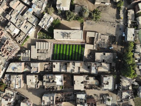 Drone captured aerial shot of a football field amidst residential buildings in البندارية, Egypt.