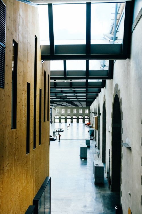 Free Explore a spacious, modern indoor corridor featuring a sleek glass ceiling and contemporary architecture. Stock Photo