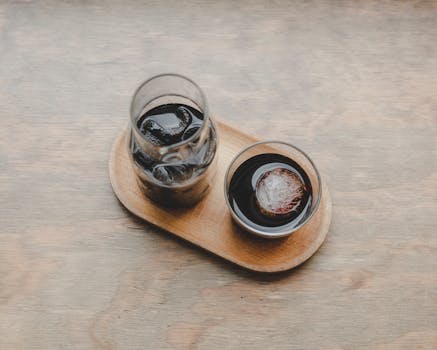 Aesthetic shot of iced coffee beverages on a wooden tray, showcasing a simple and relaxing setup.