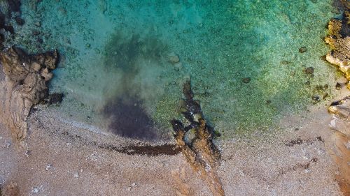 Free Stunning aerial view of the rocky shoreline and crystal-clear waters of Nardò, Puglia, Italy. Stock Photo