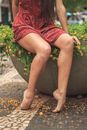 A Woman Sitting on a Large Flower Pot