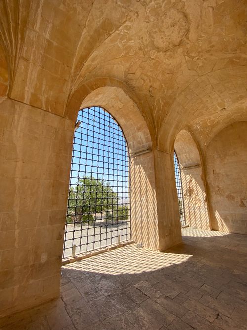 Free Sunlight casts intricate shadows through arched stone doorways at Kasimiye Madrasah, Mardin. Stock Photo