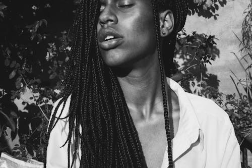 A Grayscale Photo of a Person With Dreadlocks